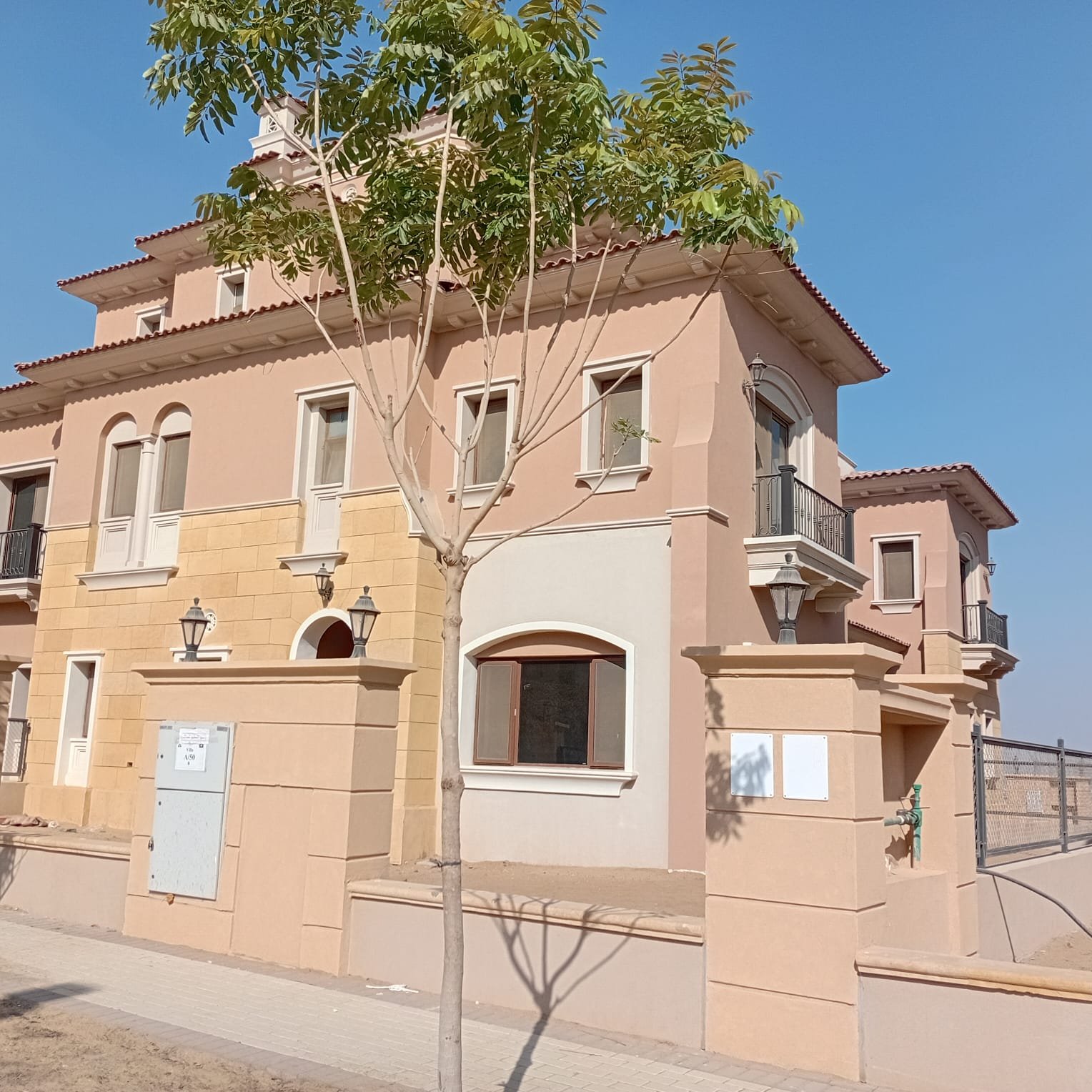 فيلا وشارع في سيتي جيت التجمع الخامس Villa front with a young tree and a small arched window - villa in CityGate, New Cairo