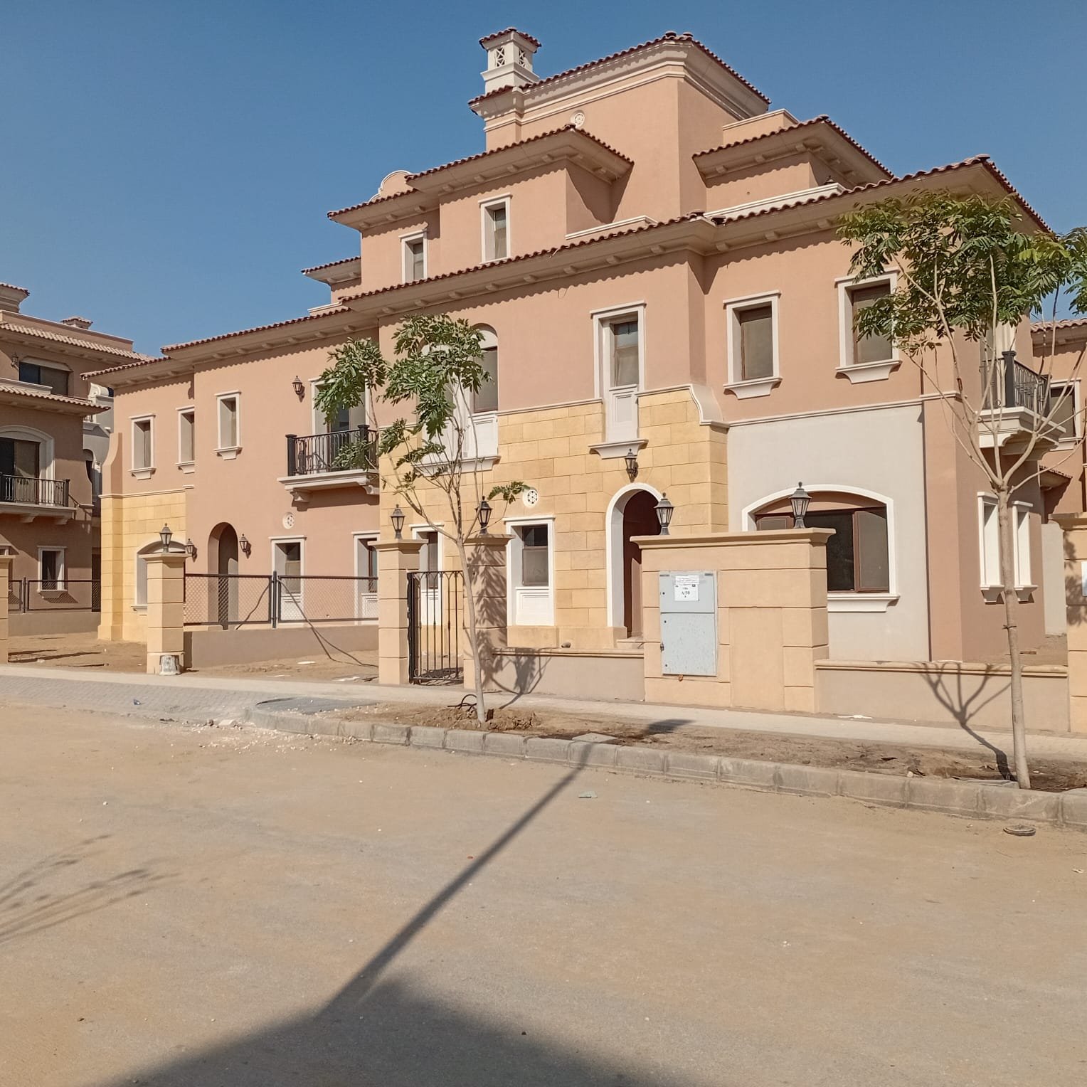 فيلا كواترو للبيع في سيتي جيت Street of villas with young trees and a paved road - villa in CityGate, New Cairo