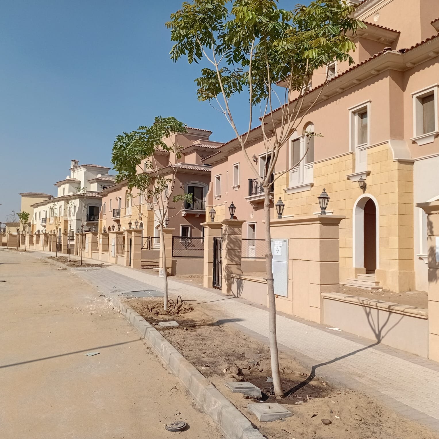 واجهة فيلا وبلكونة Villa street with new trees and a sidewalk - villa in CityGate, New Cairo