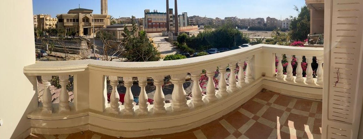 بلكونة بدرابزين أبيض منحنٍ تطل على الشارع - شقة في الحي الثالث التجمع الخامس