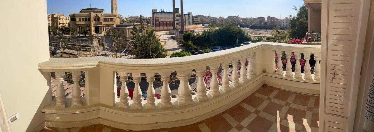 بلكونة بدرابزين أبيض منحنٍ تطل على الشارع - شقة في الحي الثالث التجمع الخامس