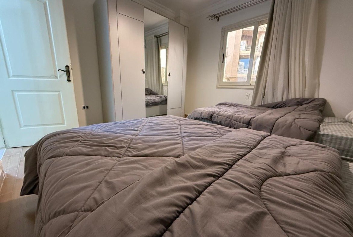 Twin beds with grey duvets and a wardrobe - apartment in Dar Misr Al Koronfol New Cairo – 3 Bedrooms 130 sqm, New Cairo