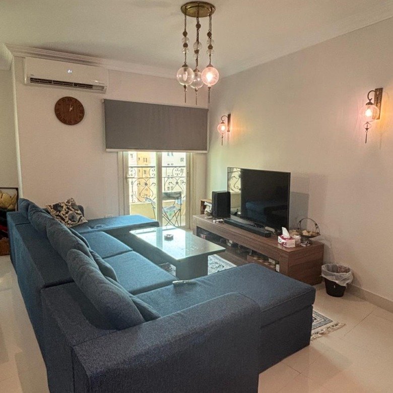 Furnished living room with corner sofa and TV, duplex for rent in Al Banafseg New Cairo - غرفة معيشة مفروشة بركنة وتلفزيون، دوبلكس للإيجار في البنفسج القاهرة الجديدة