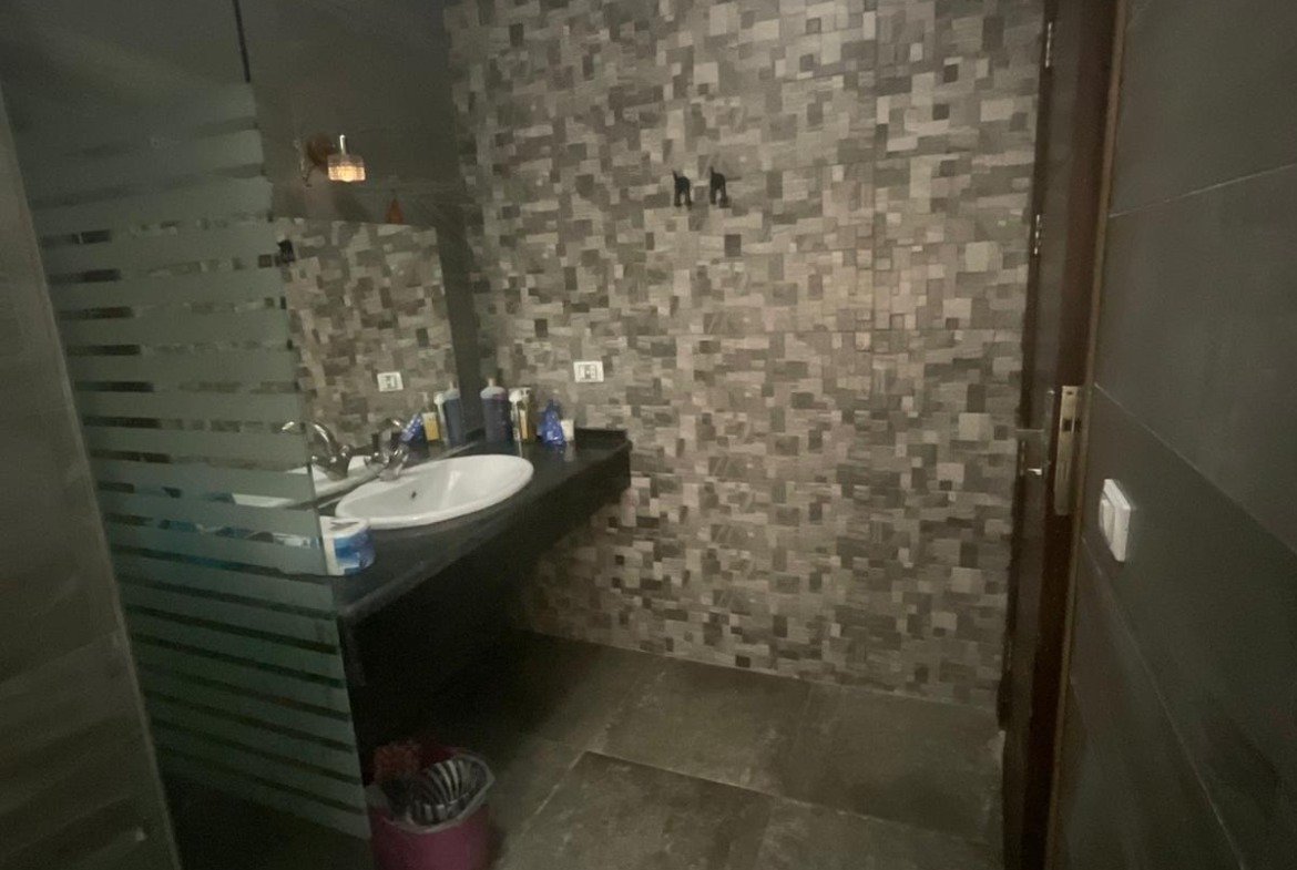 Bathroom with stone wall and glass shower, duplex in Al Banafseg - حمام بحائط حجر وشاور زجاج، دوبلكس في البنفسج