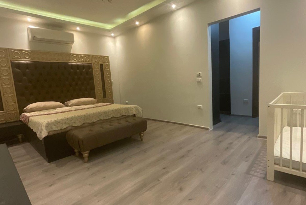 Master suite bedroom with lighting and wardrobe area, Al Banafseg 3 villas - غرفة نوم الجناح بإضاءة وركن دريسينج، فيلات البنفسج 3
