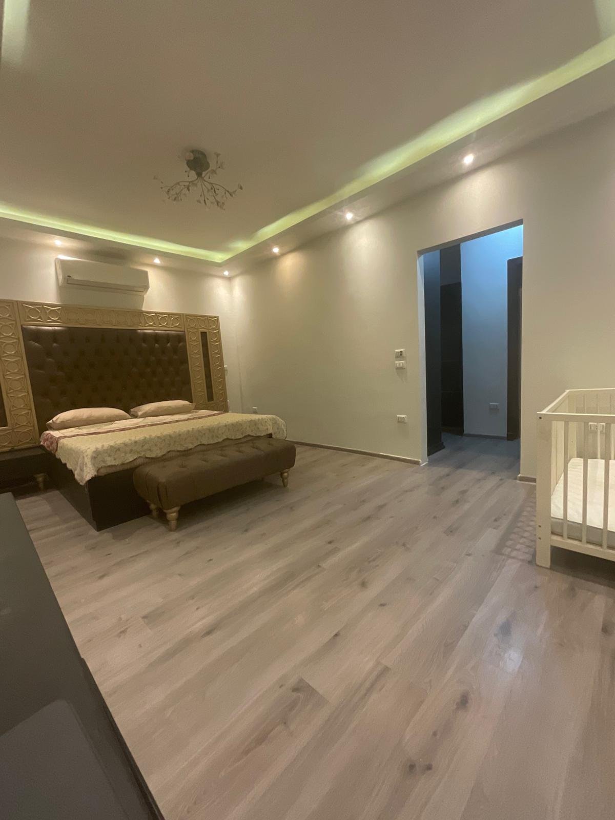 duplex-for-sale-al-banafseg-3-villas-new-cairo-360-sqm-garden-bedroom Master suite bedroom with lighting and wardrobe area, Al Banafseg 3 villas - غرفة نوم الجناح بإضاءة وركن دريسينج، فيلات البنفسج 3