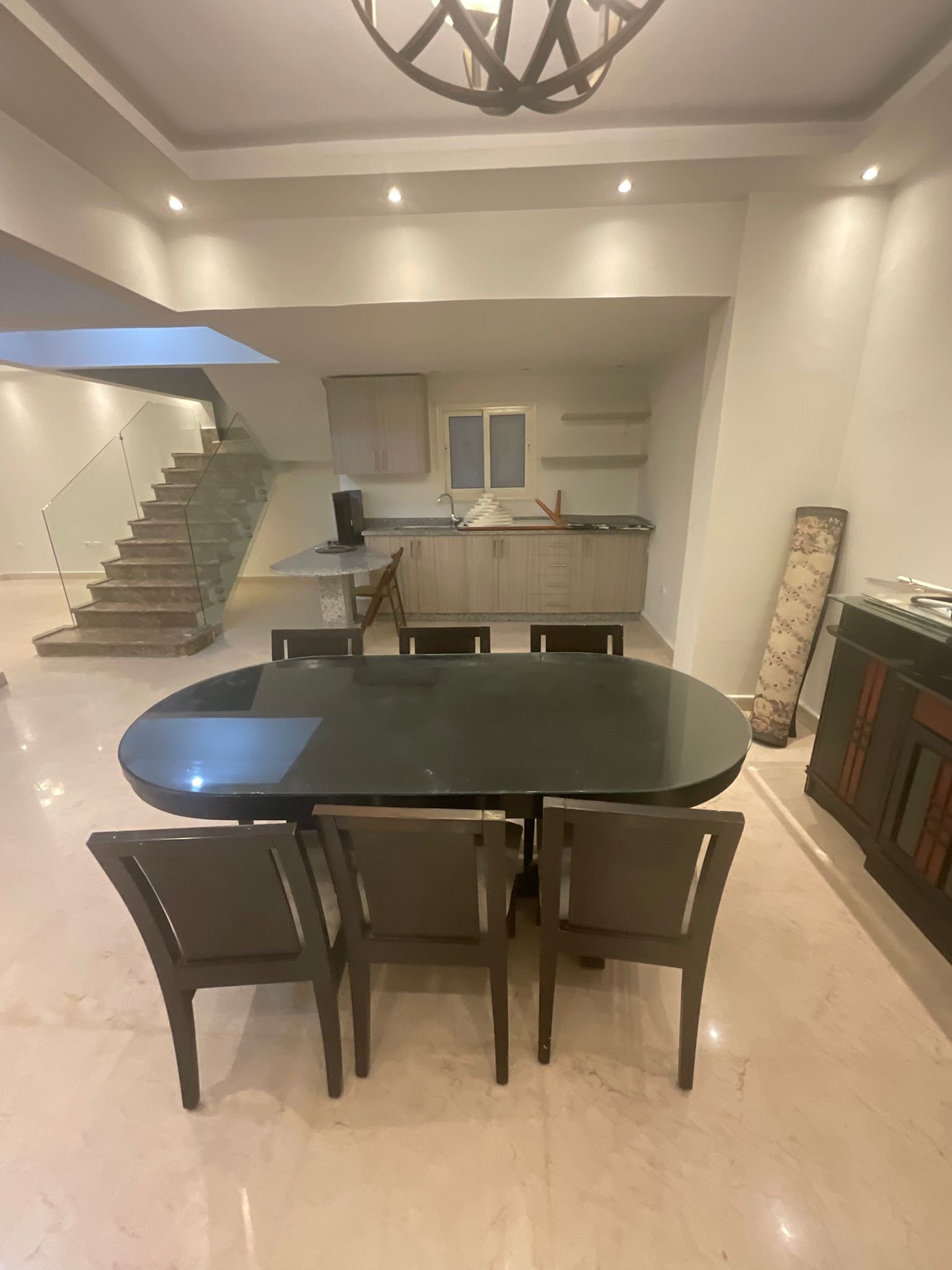 duplex-for-sale-al-banafseg-3-villas-new-cairo-360-sqm-garden-dining-2 Dining table and open kitchen with staircase, Al Banafseg duplex - سفرة ومطبخ مفتوح مع السلم، دوبلكس البنفسج