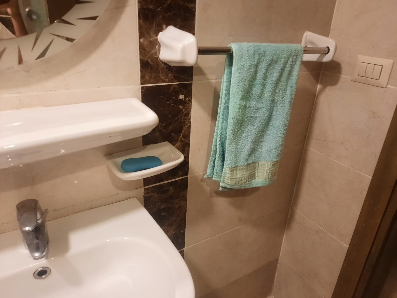 Washbasin with a soap dish and a green towel - duplex in Porto, New Cairo