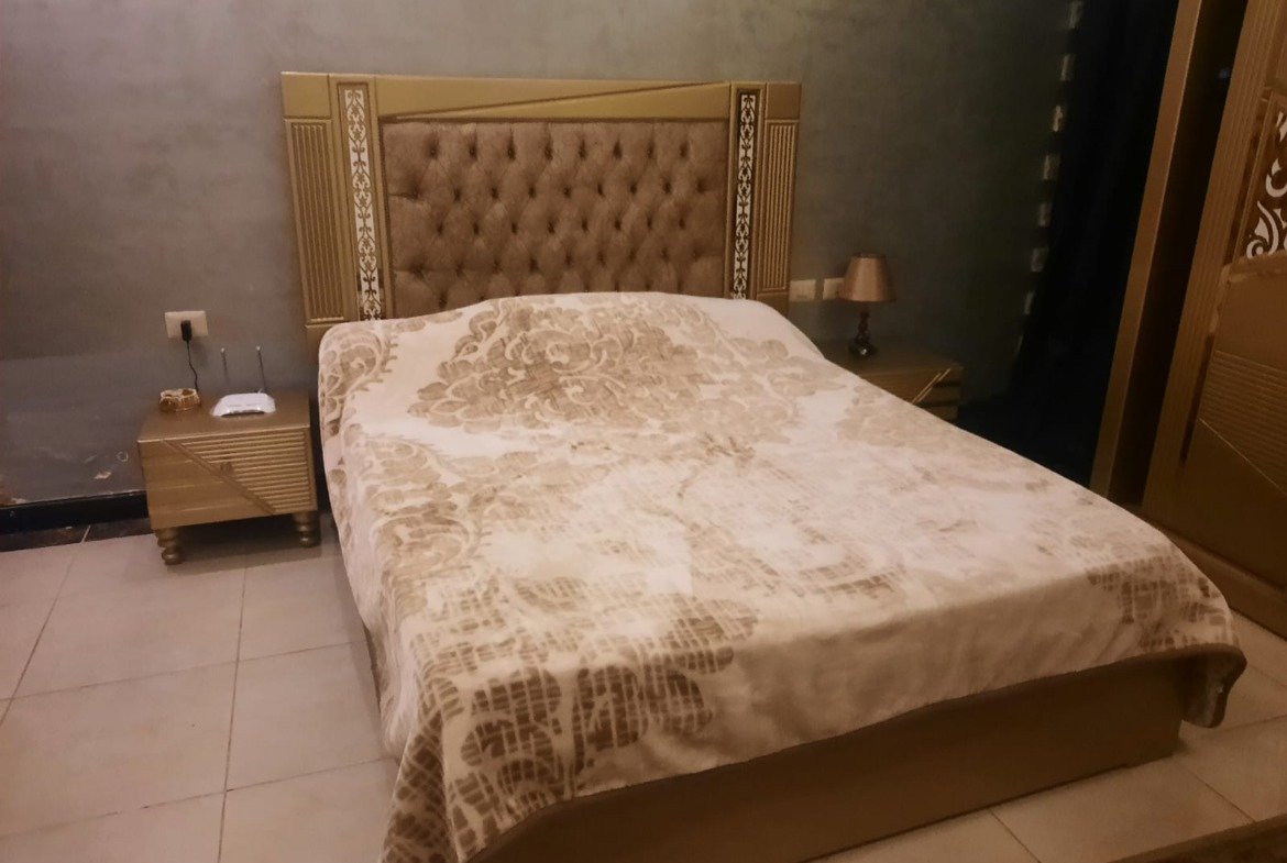 Bedroom with a quilted headboard and a patterned bed cover - duplex in Porto, New Cairo