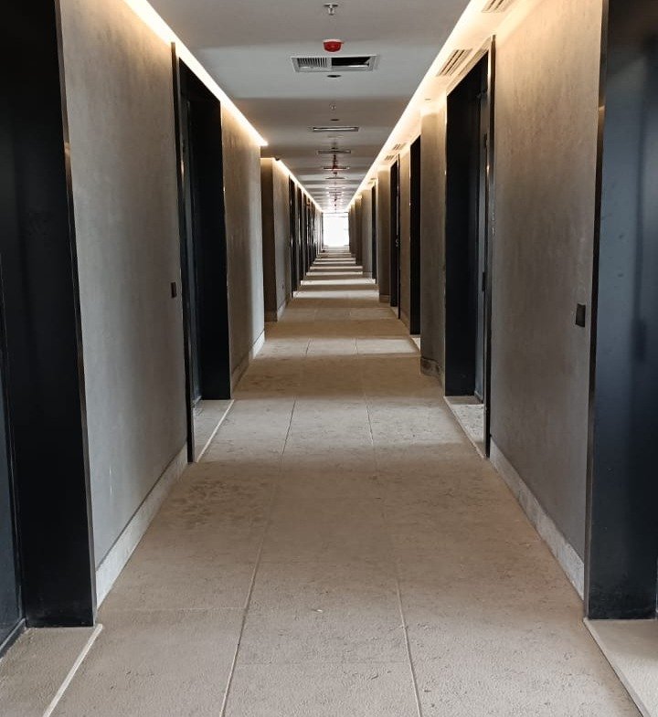 Long hallway with dark doors and a carpeted floor - unit in Marassi