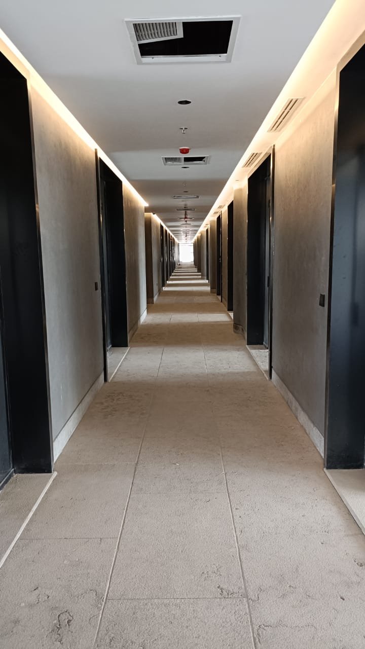Long hallway with dark doors and a carpeted floor - unit in Marassi