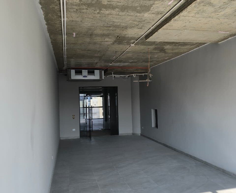 Long shell space with sunlight patches on the floor and a concrete ceiling - unit in Marassi