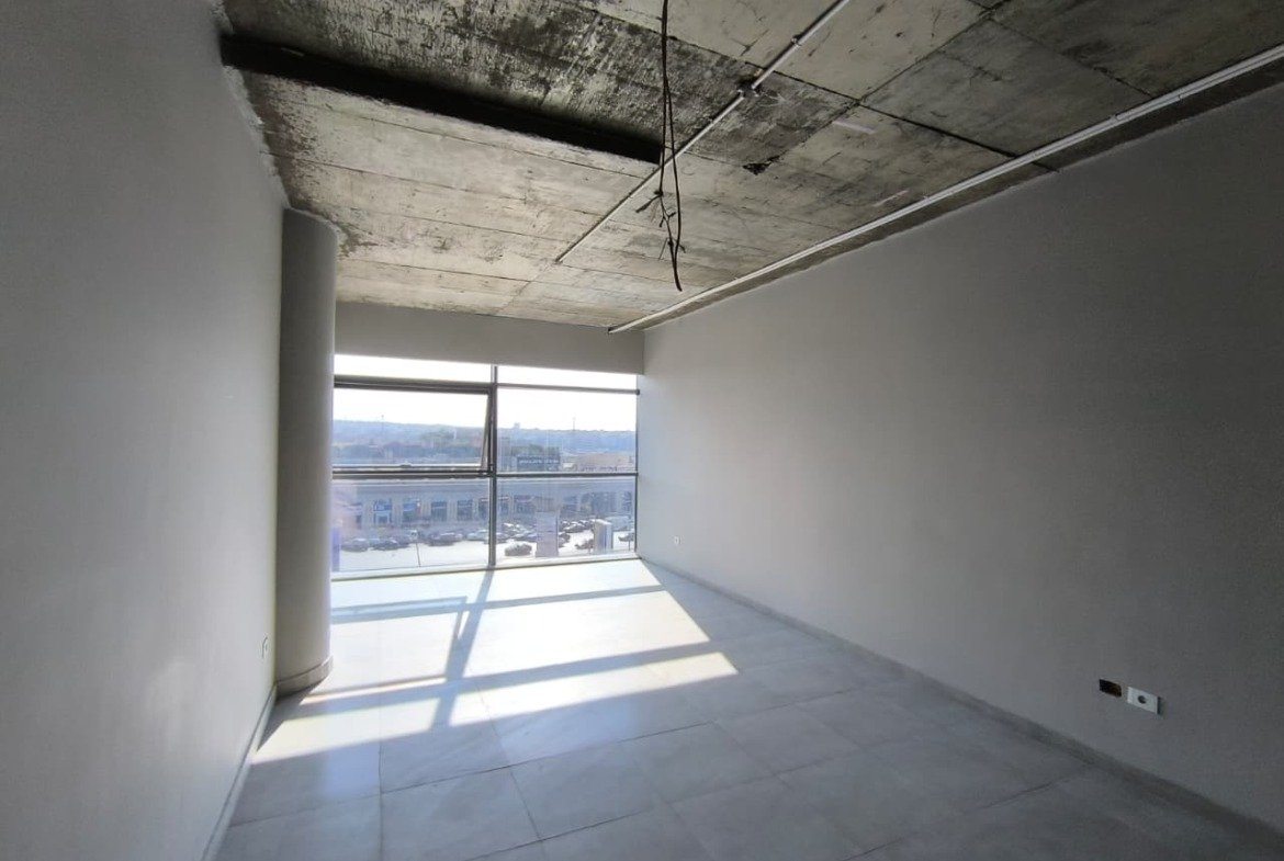 Shell room with a full-width window and a bare concrete ceiling - unit in Marassi