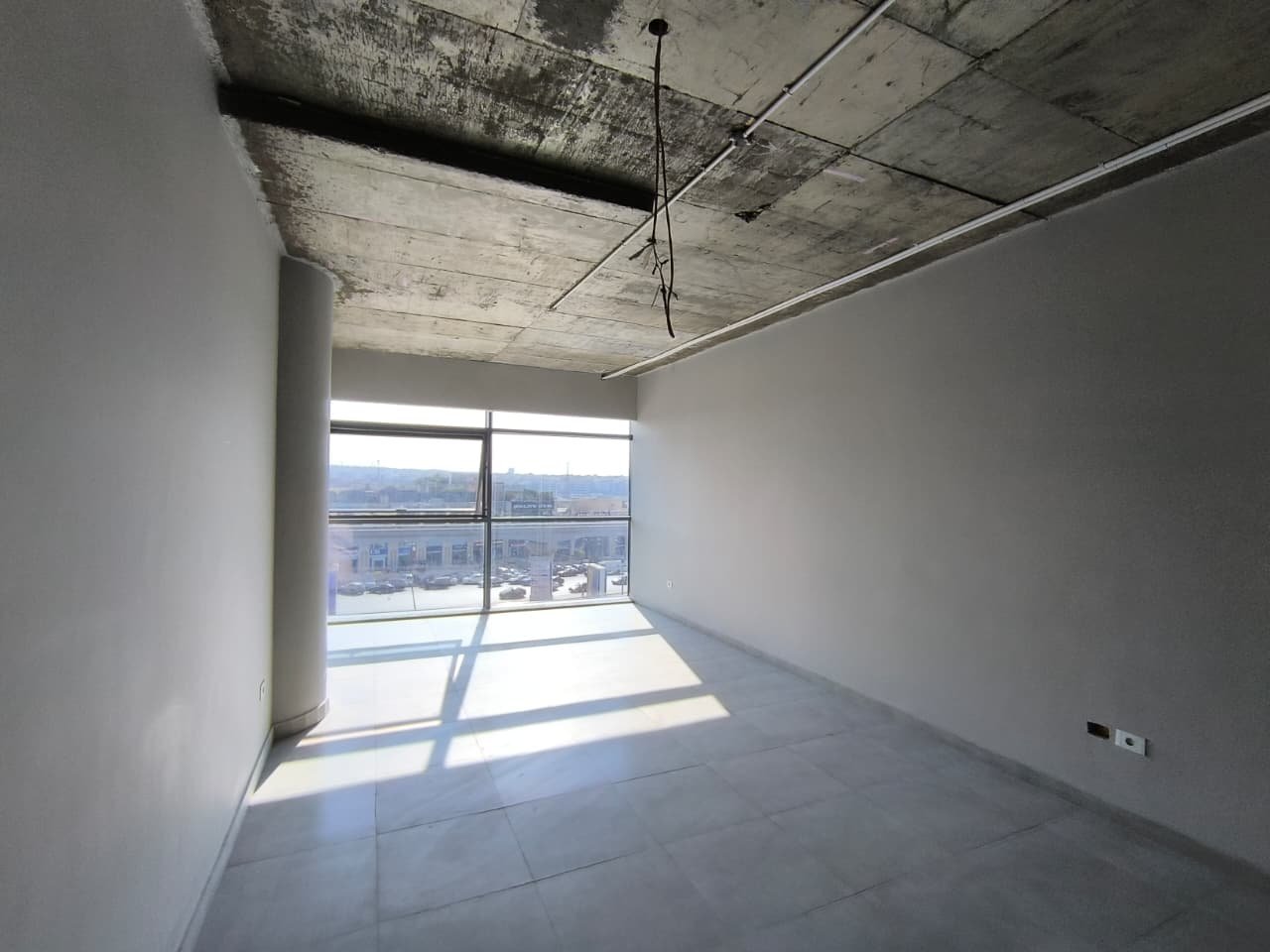 Shell room with a full-width window and a bare concrete ceiling - unit in Marassi