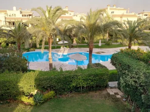 Swimming pool surrounded by palms and lawns - El Patio 1, New Cairo twinhouse
