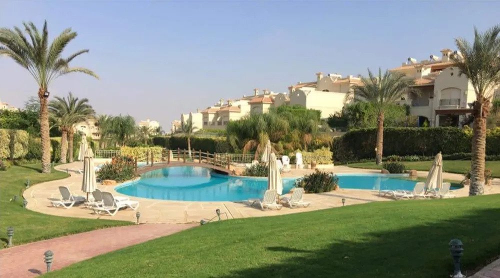 حمام سباحة مع مسطح أخضر واسع وكراسي استلقاء - فيلا في الباتيو 6، الجيزة