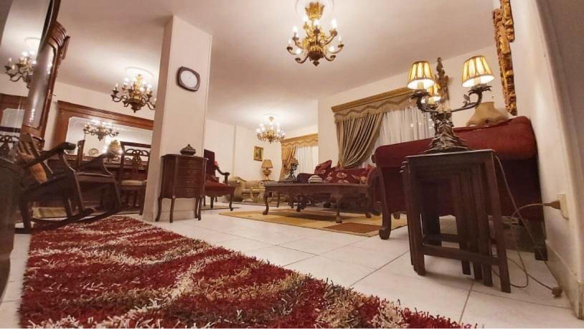 Classic reception with a red rug and wooden furniture - apartment in El Rehab New Cairo – 3 Bedrooms 183 sqm – Garden View, New Cairo