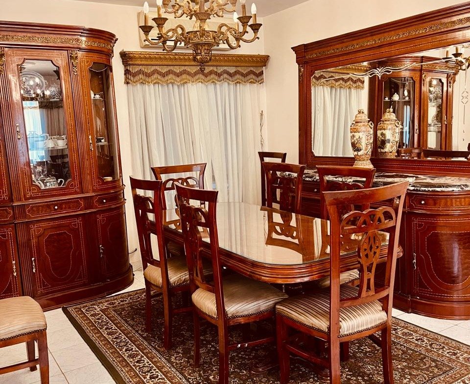 Dining room with a sideboard mirror and patterned rug - apartment in El Rehab New Cairo – 3 Bedrooms 183 sqm – Garden View, New Cairo