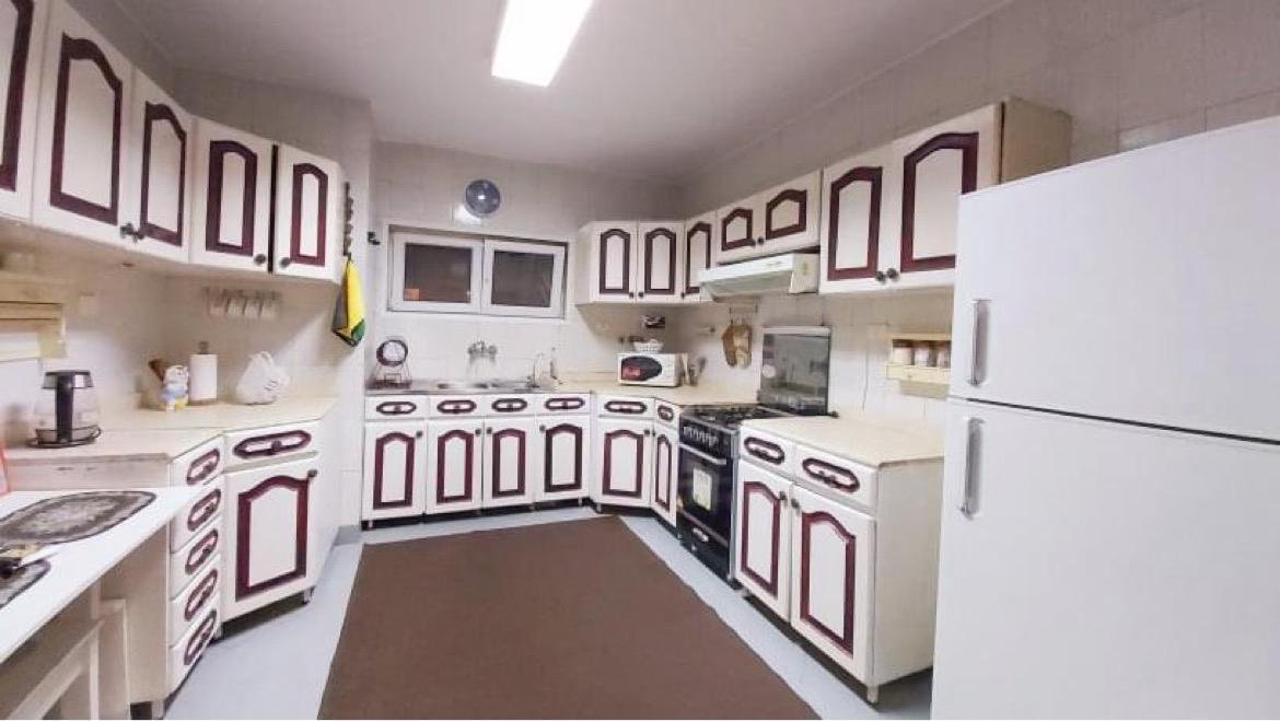 Large kitchen with white and burgundy cabinets - apartment in El Rehab New Cairo – 3 Bedrooms 183 sqm – Garden View, New Cairo