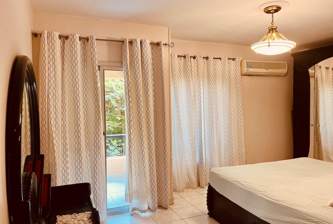 Bedroom with a dressing mirror and sheer curtains at the terrace door - apartment in El Rehab New Cairo – 3 Bedrooms 183 sqm – Garden View, New Cairo
