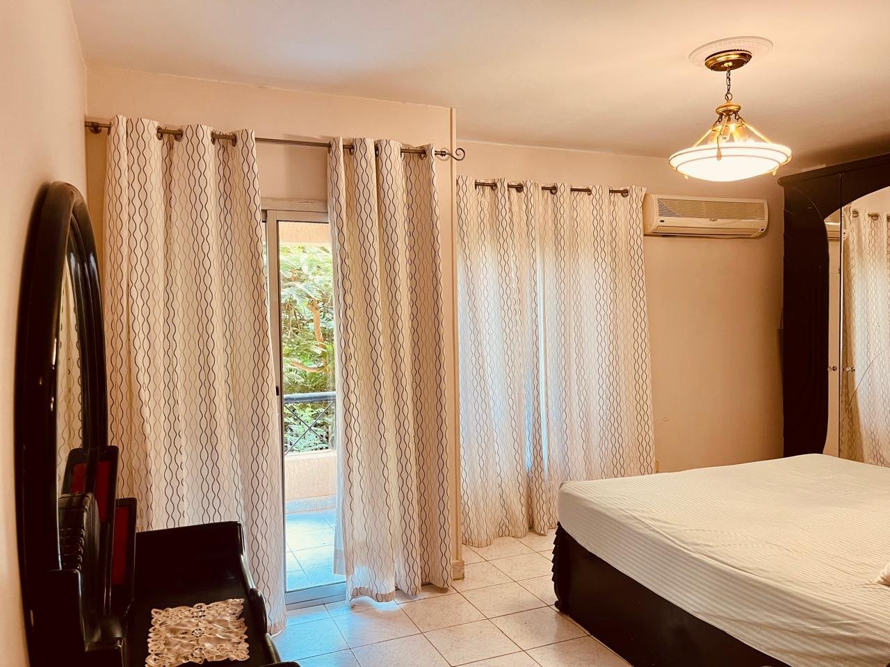 el-rehab-apt-rent-108-10 Bedroom with a dressing mirror and sheer curtains at the terrace door - apartment in El Rehab New Cairo – 3 Bedrooms 183 sqm – Garden View, New Cairo