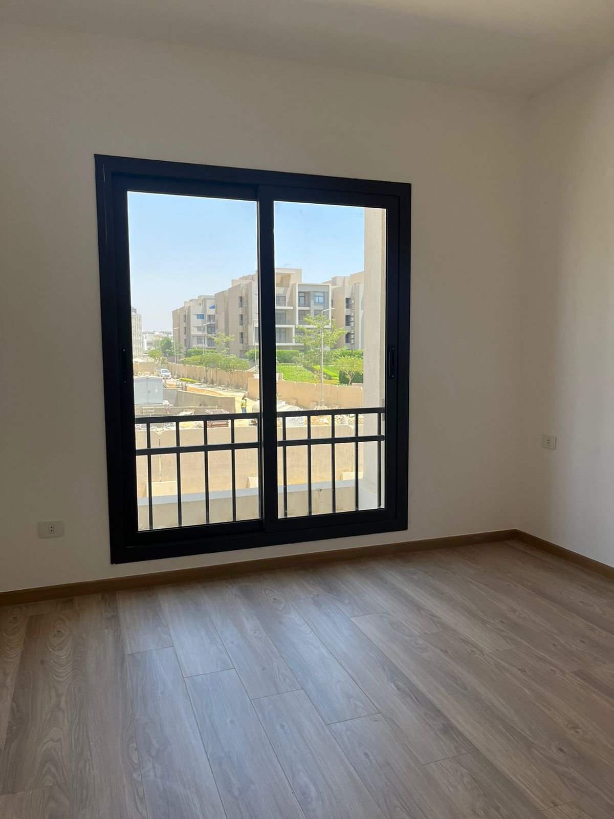 Empty room with balcony window and garden view - apartment in Fifth Square, New Cairo