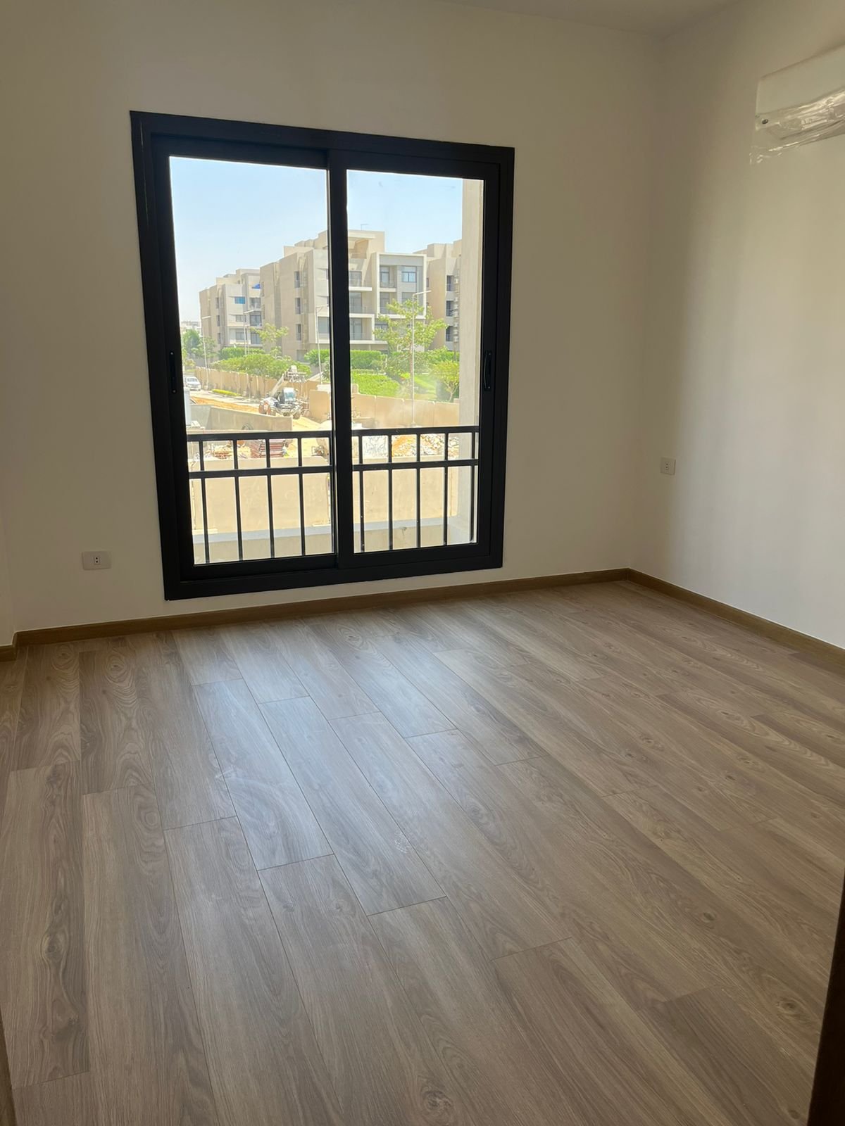 Empty bedroom with window and wooden floor - apartment in Fifth Square, New Cairo
