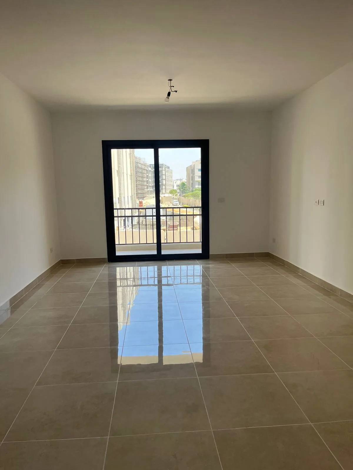 Empty living room with balcony door - apartment in Fifth Square, New Cairo