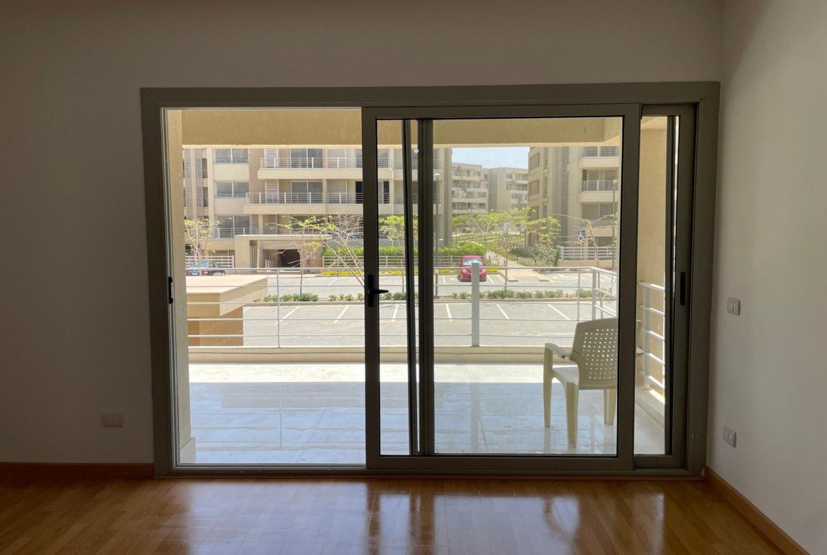 Empty room with a wide sliding glass door facing the garden - apartment in Capital Gardens Next to Madinaty, Mostaqbal City