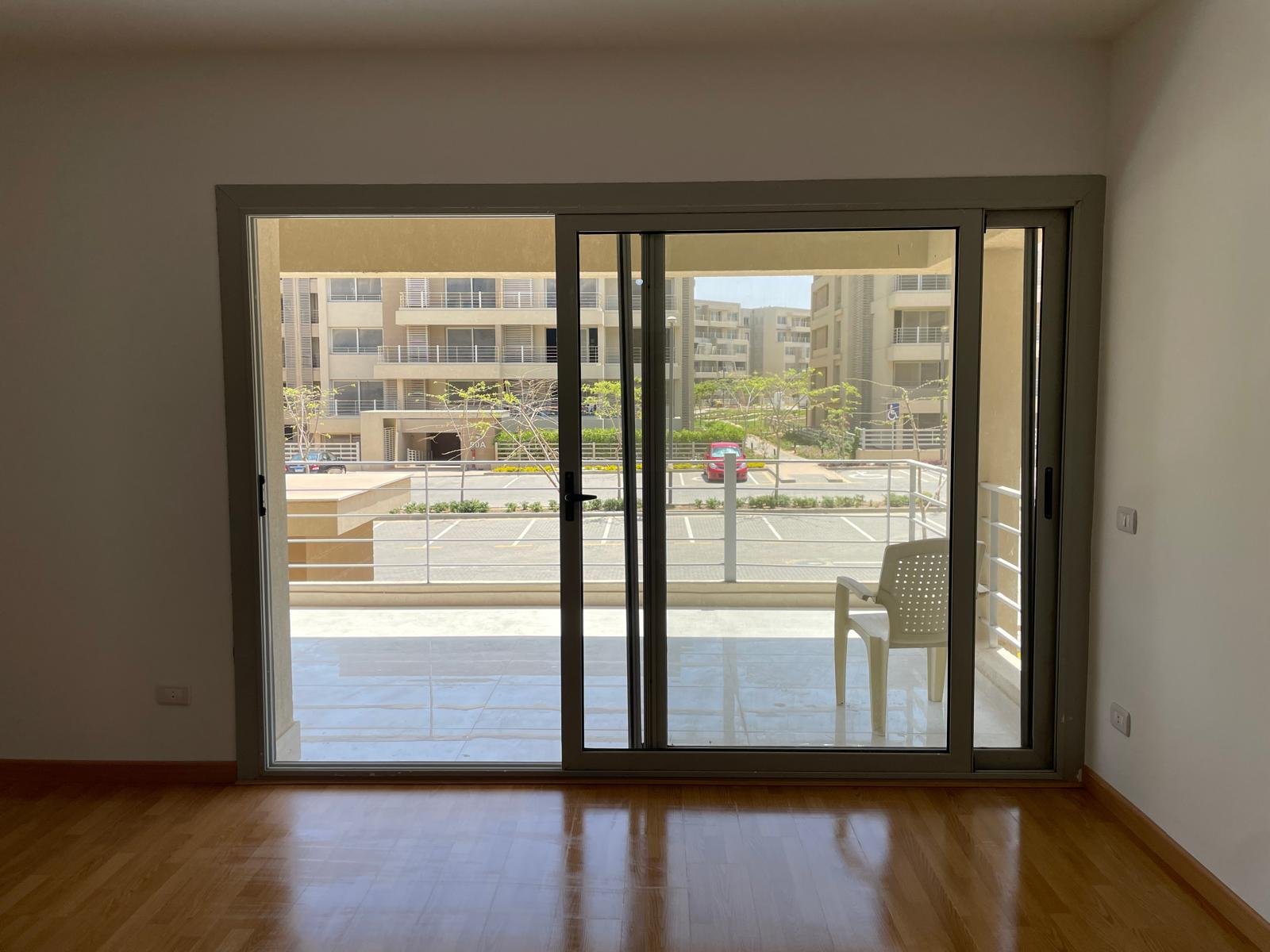 Empty room with a wide sliding glass door facing the garden - apartment in Capital Gardens Next to Madinaty, Mostaqbal City