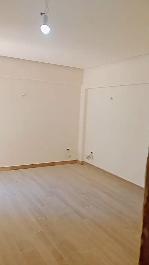 Empty room with laminate flooring and white walls - apartment in Mountain View iCity, New Cairo
