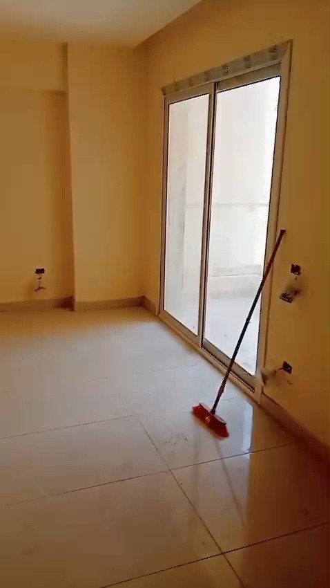 Empty room with a sliding glass door and a mop leaning on the wall - apartment in Mountain View iCity, New Cairo