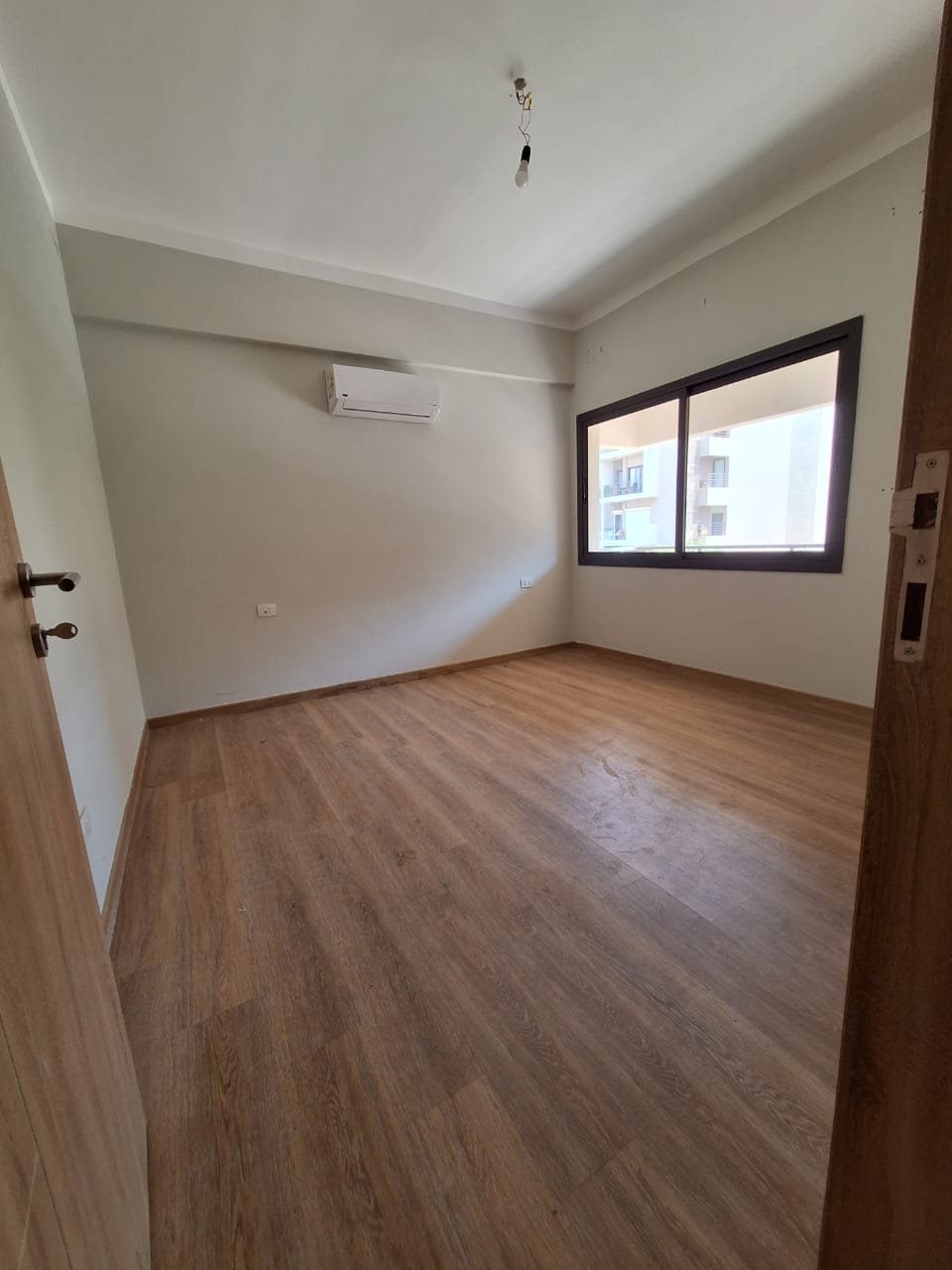 Empty bedroom with window and wooden floor - apartment in Fifth Square, New Cairo