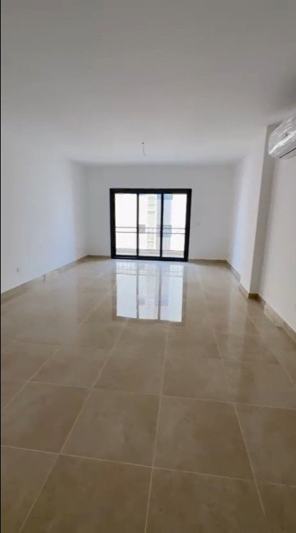 Empty reception with balcony door - apartment in Fifth Square, New Cairo