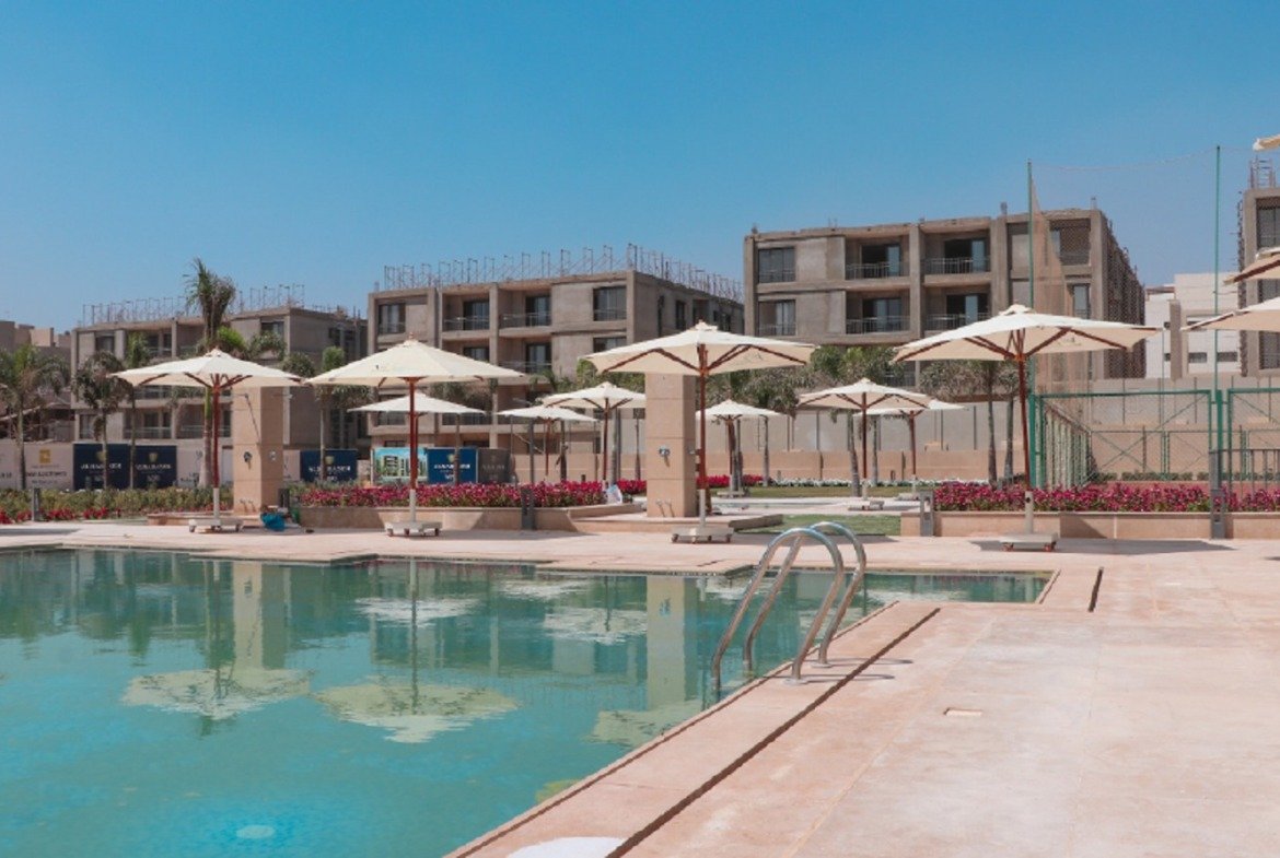 Swimming pool with umbrellas and apartment buildings - apartment in Fifth Square, New Cairo