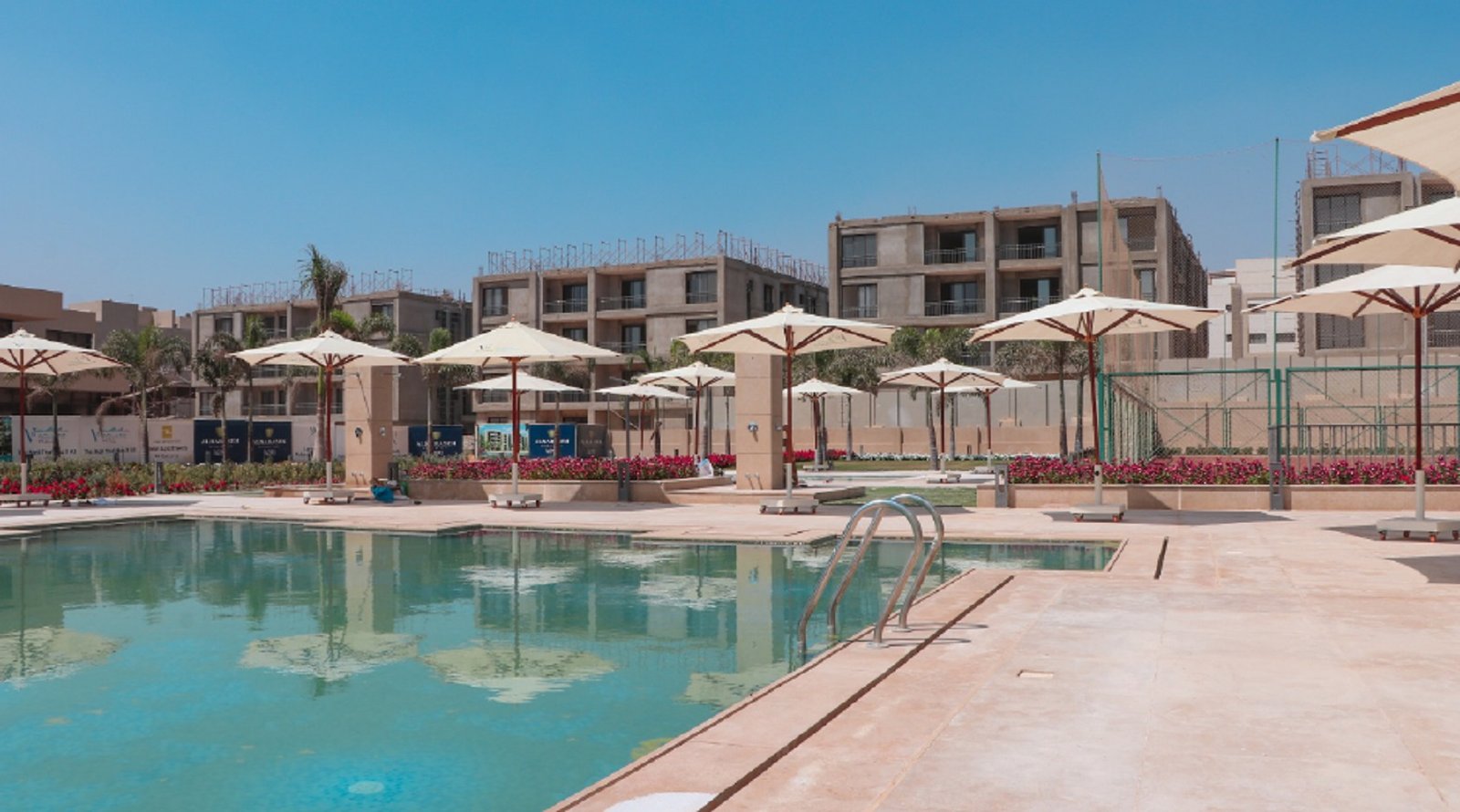Swimming pool with umbrellas and apartment buildings - apartment in Fifth Square, New Cairo