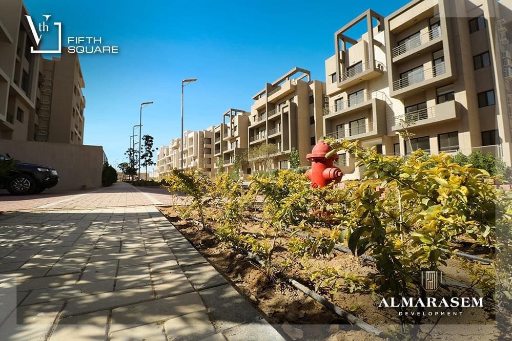 Planted walkway beside the buildings - apartment in Fifth Square, New Cairo