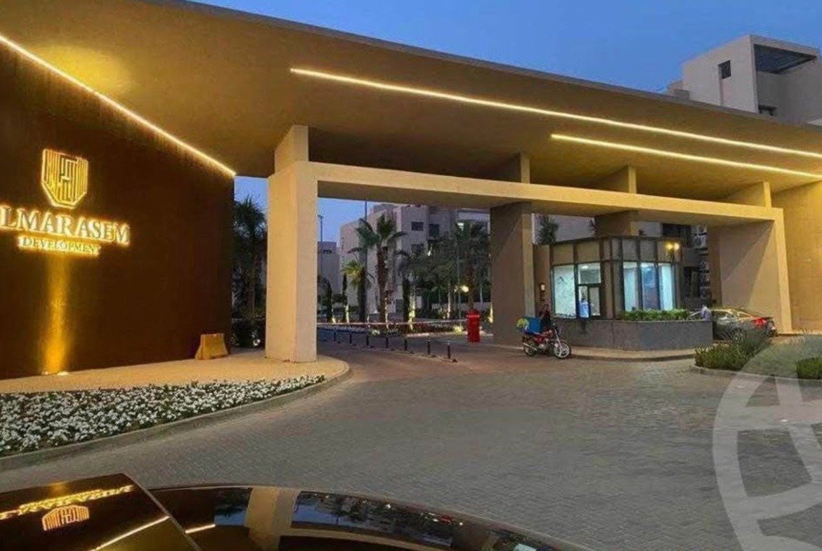 Al Marasem compound entrance gate at dusk - apartment in Fifth Square, New Cairo