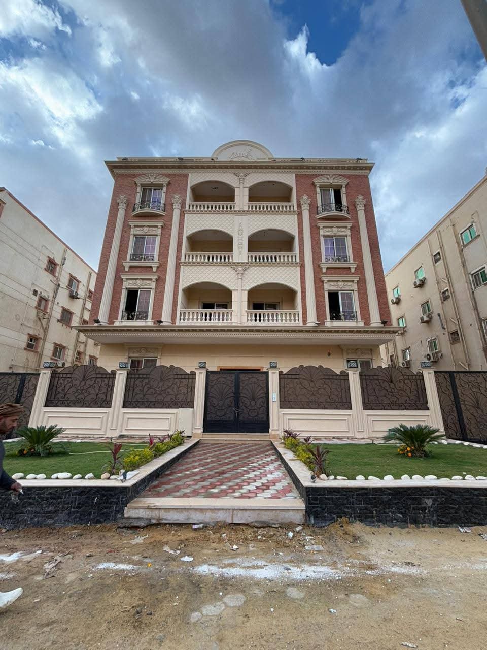 Front of a four-floor apartment building with a central stair path - apartment in Gharb Arabella, 5th Settlement