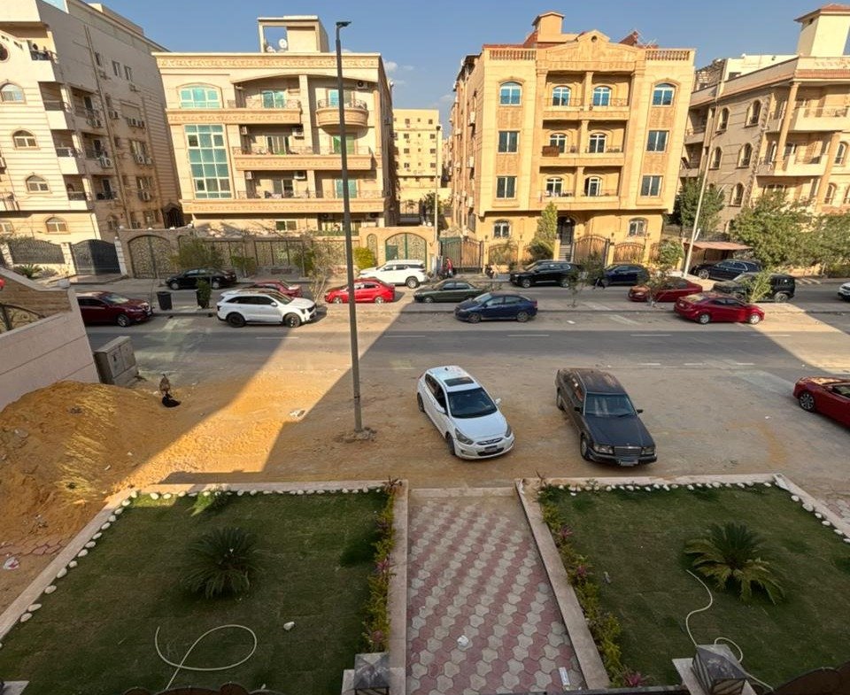 View over a parking court and garden beds between residential buildings - apartment in Gharb Arabella, 5th Settlement