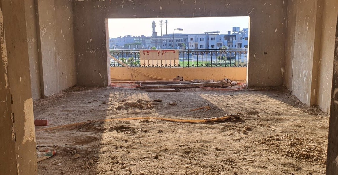 Unfinished room with a wide window opening and a sandy floor - apartment in Gharb Golf 5th Settlement