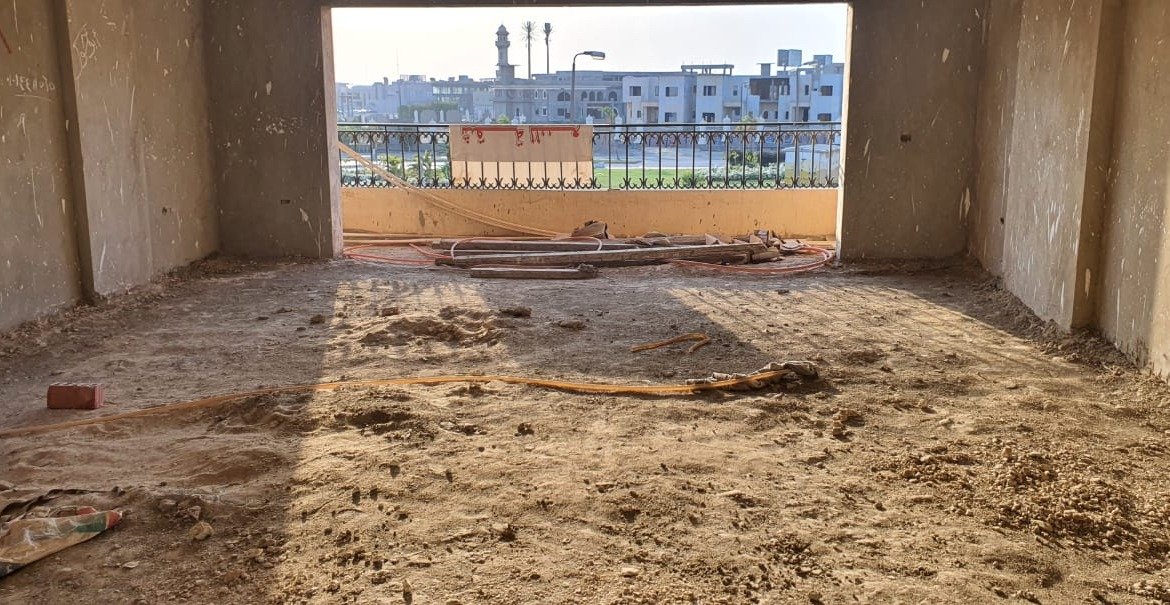 Bare concrete room with a large opening and a sandy floor - apartment in Gharb Golf 5th Settlement