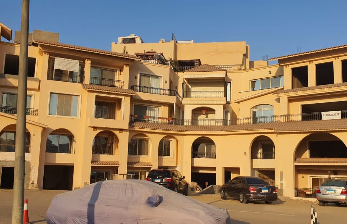 Yellow arched apartment building with ground-floor parking - apartment in Gharb Golf 5th Settlement