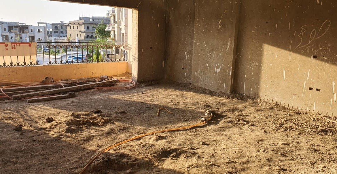Bare room with a wide opening and a sandy floor in sunlight - apartment in Gharb Golf 5th Settlement