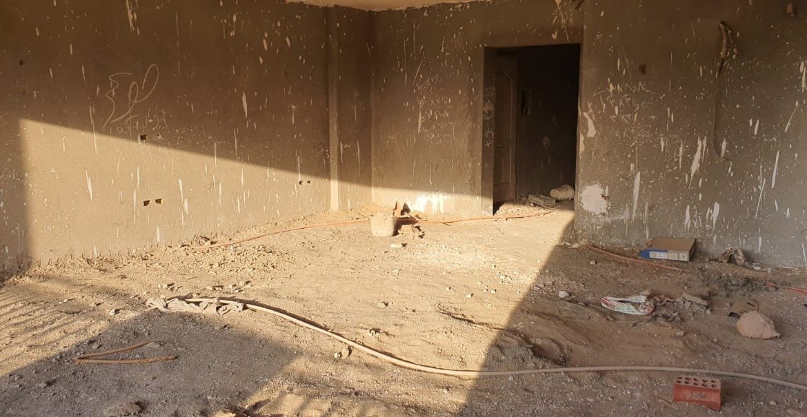 Large bare room with a dark door opening in sunlight - apartment in Gharb Golf 5th Settlement