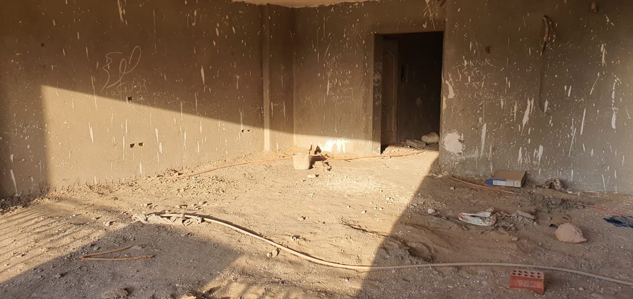 gharb-golf-apt-260-09 Large bare room with a dark door opening in sunlight - apartment in Gharb Golf 5th Settlement