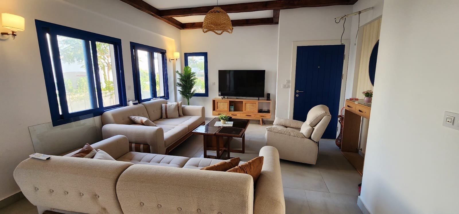 Living room with beige sofas and blue windows - townhouse in Marassi, North Coast