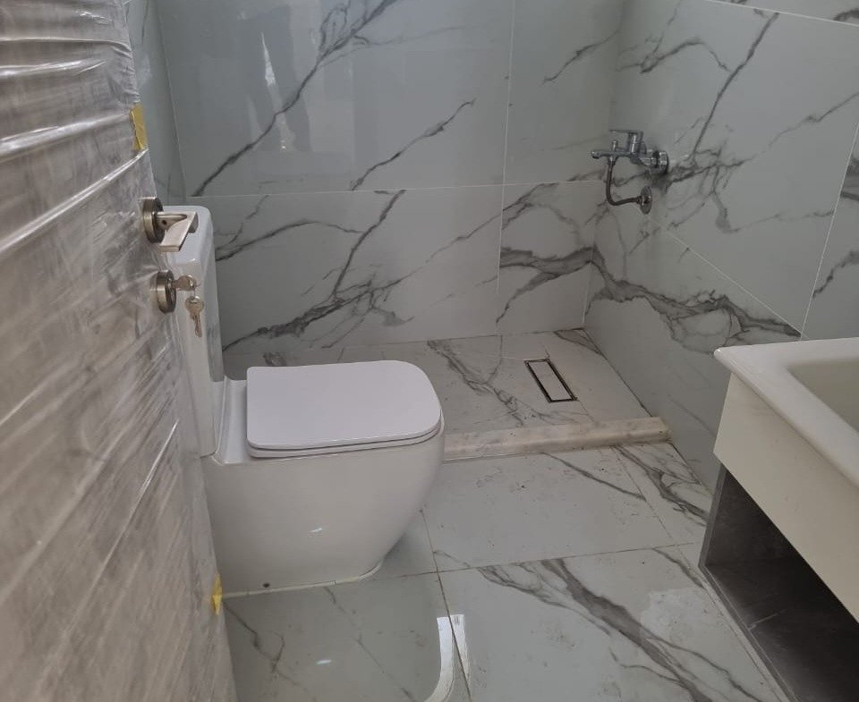 Bathroom with marble-look walls, a wall-hung toilet and a vanity - apartment in Green Square, Mostaqbal City