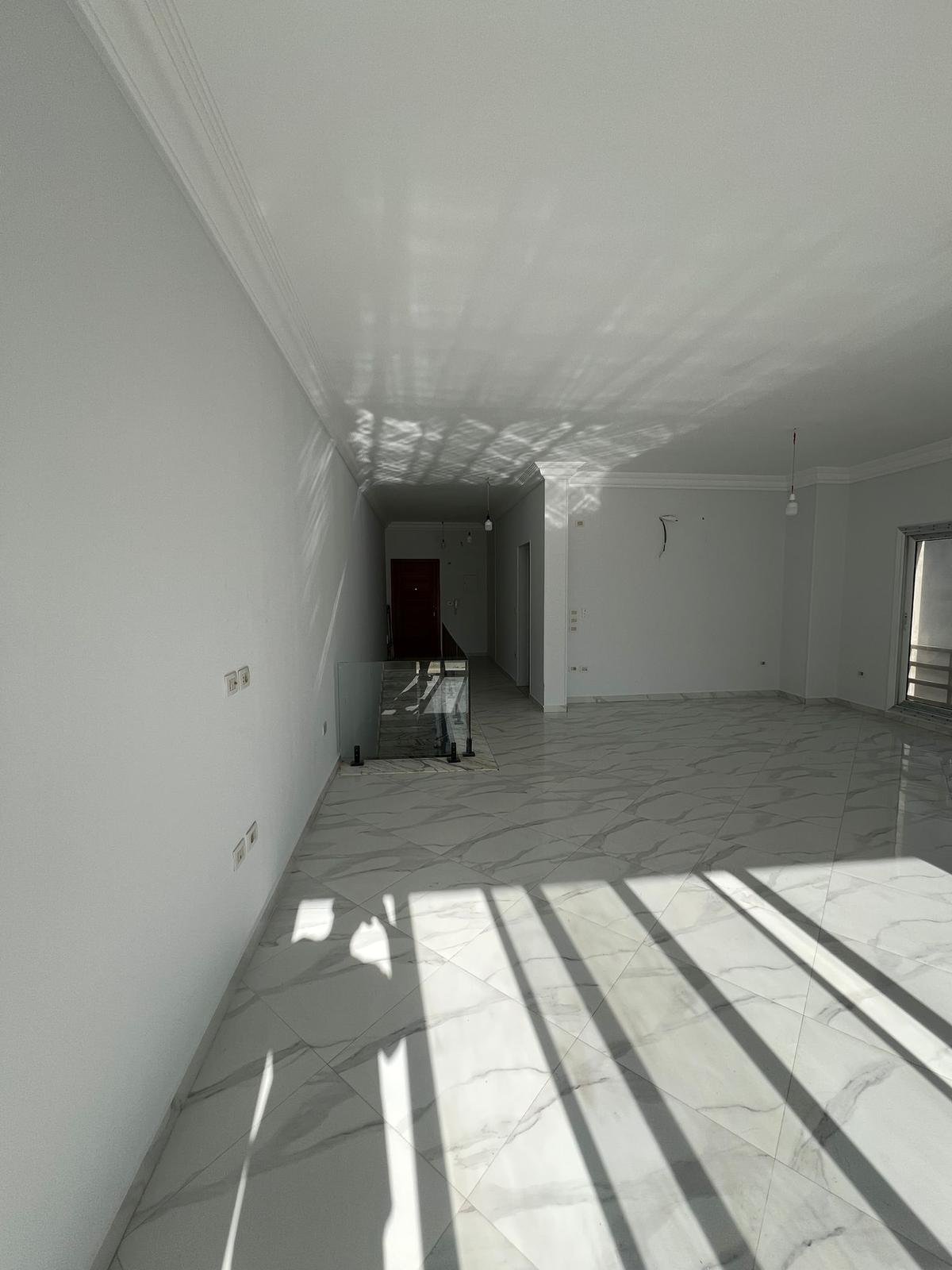 Empty room with floor shadows - duplex in Hyde Park, New Cairo