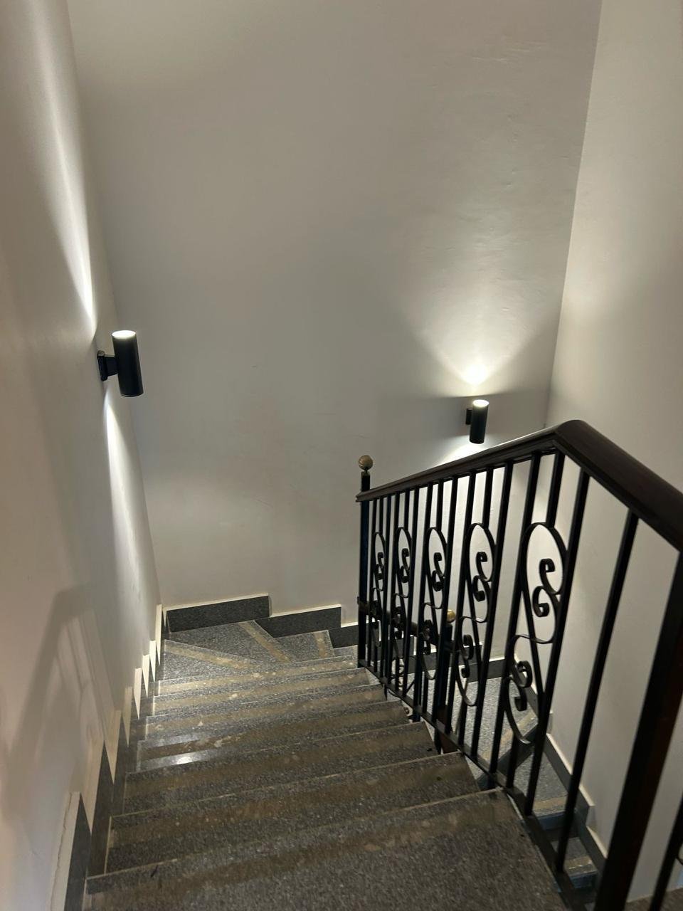 Staircase with a wrought-iron railing and wall lights - duplex in Jayd New Cairo – 3 Bedrooms 260 sqm with Private Garden, New Cairo